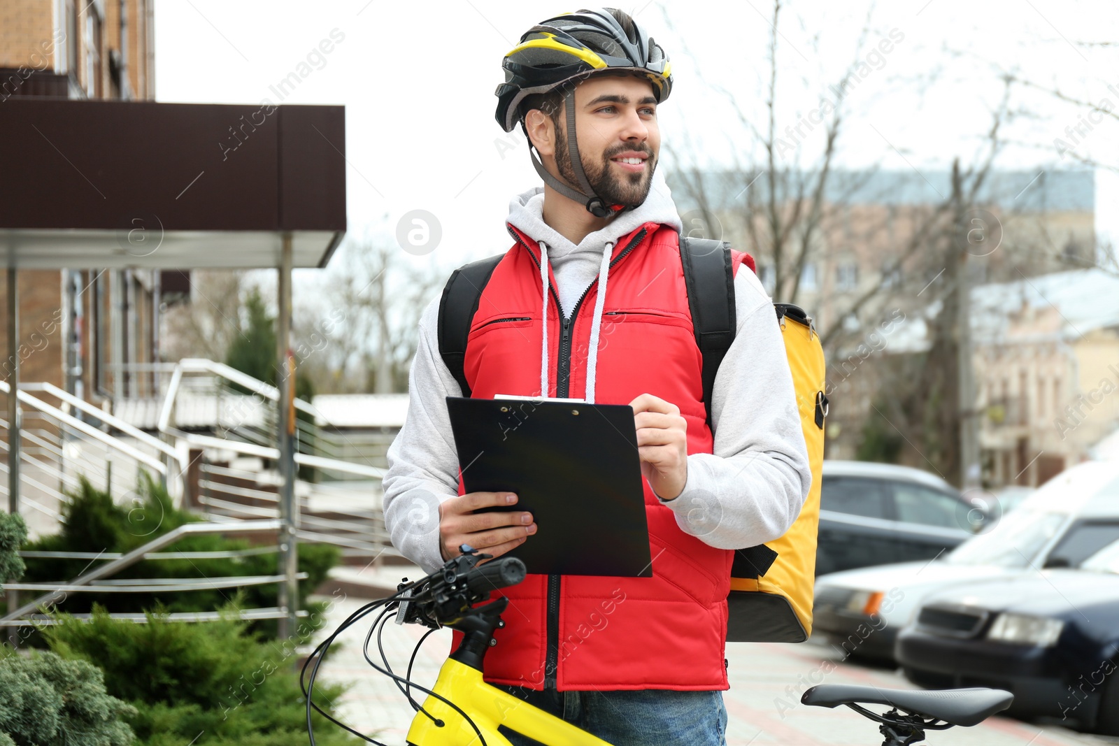 Photo of Courier with thermo bag and clipboard on city street. Food delivery service