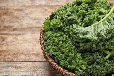 Fresh kale leaves on wooden table, closeup