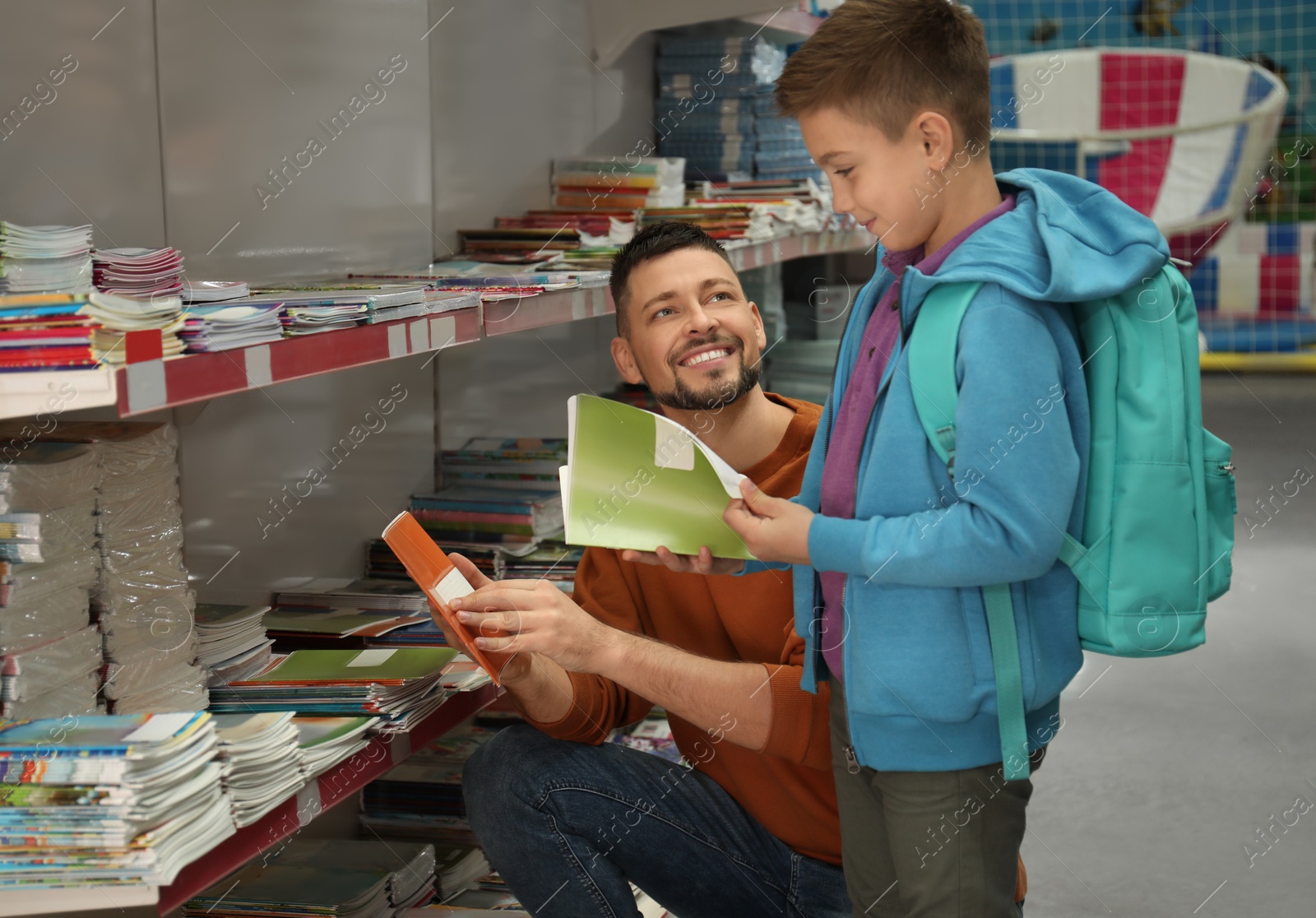 Photo of Little boy and father choosing school stationery in store