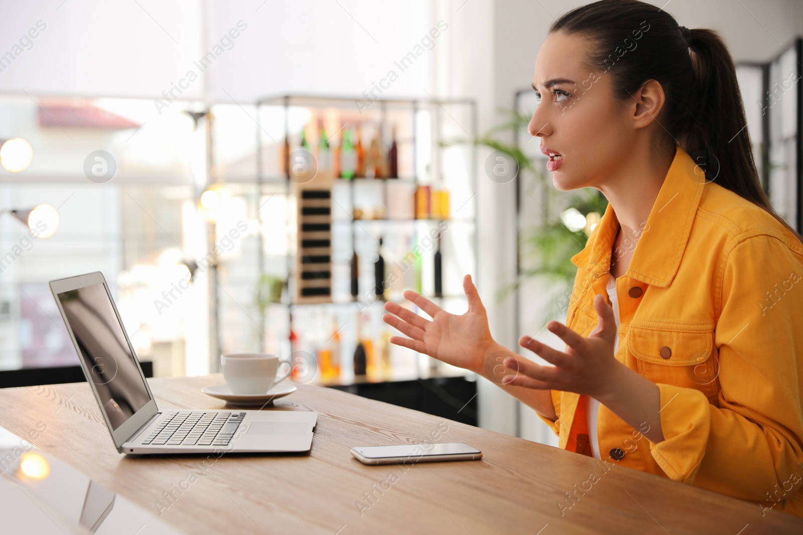 Photo of Emotional young woman working on laptop in office. Online hate concept