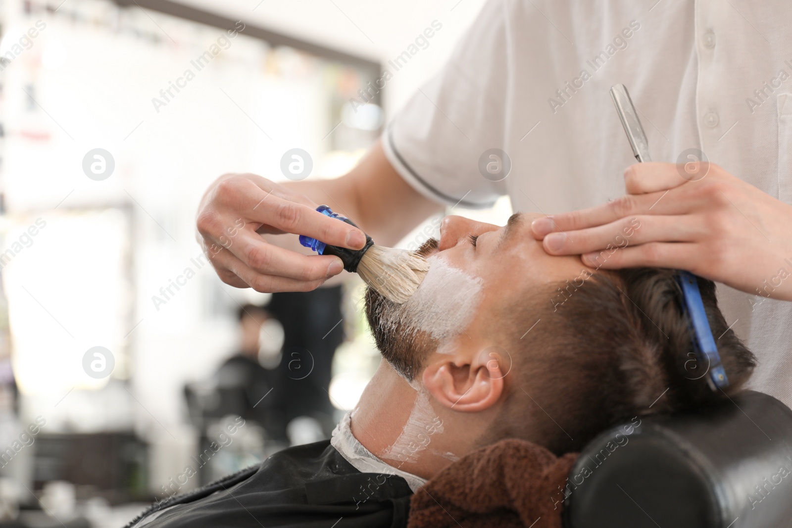 Photo of Professional barber working with client in hairdressing salon. Hipster fashion