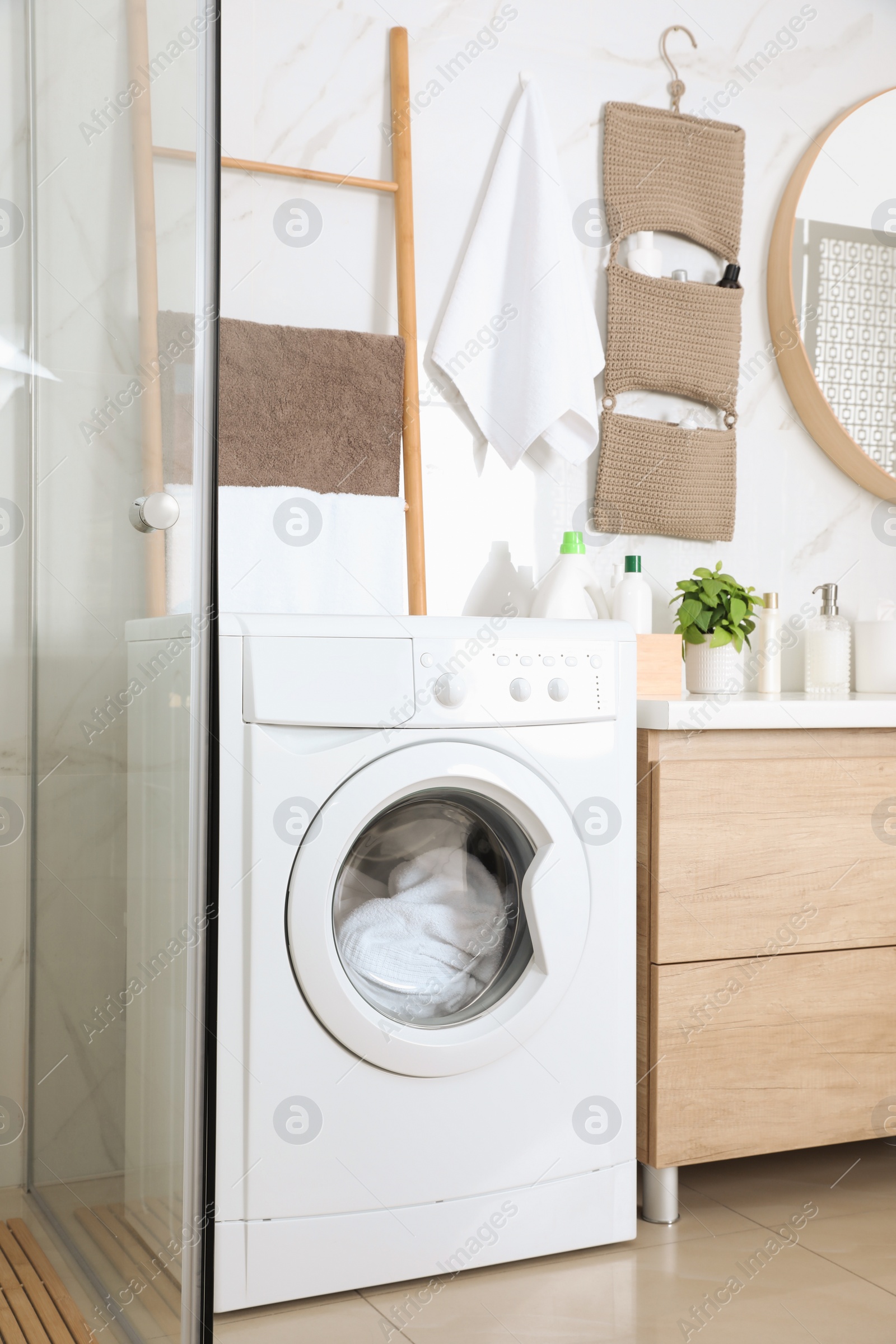 Photo of Stylish bathroom interior with modern washing machine