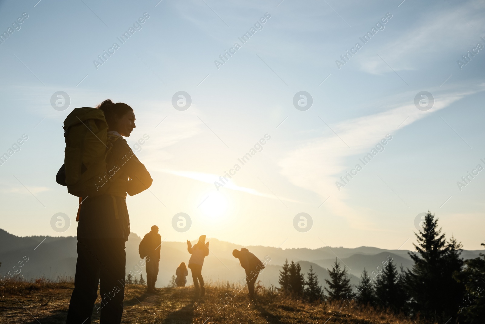 Photo of Tourists with backpacks in mountains on sunset