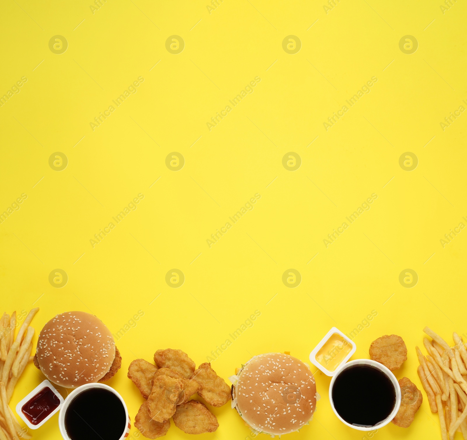 Photo of Different fast food on yellow background, flat lay. Space for text