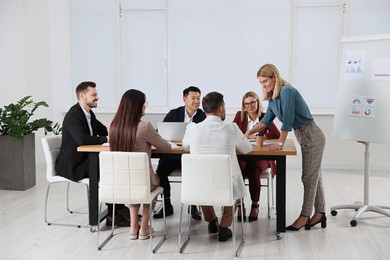 Businesswoman having meeting with her employees in office