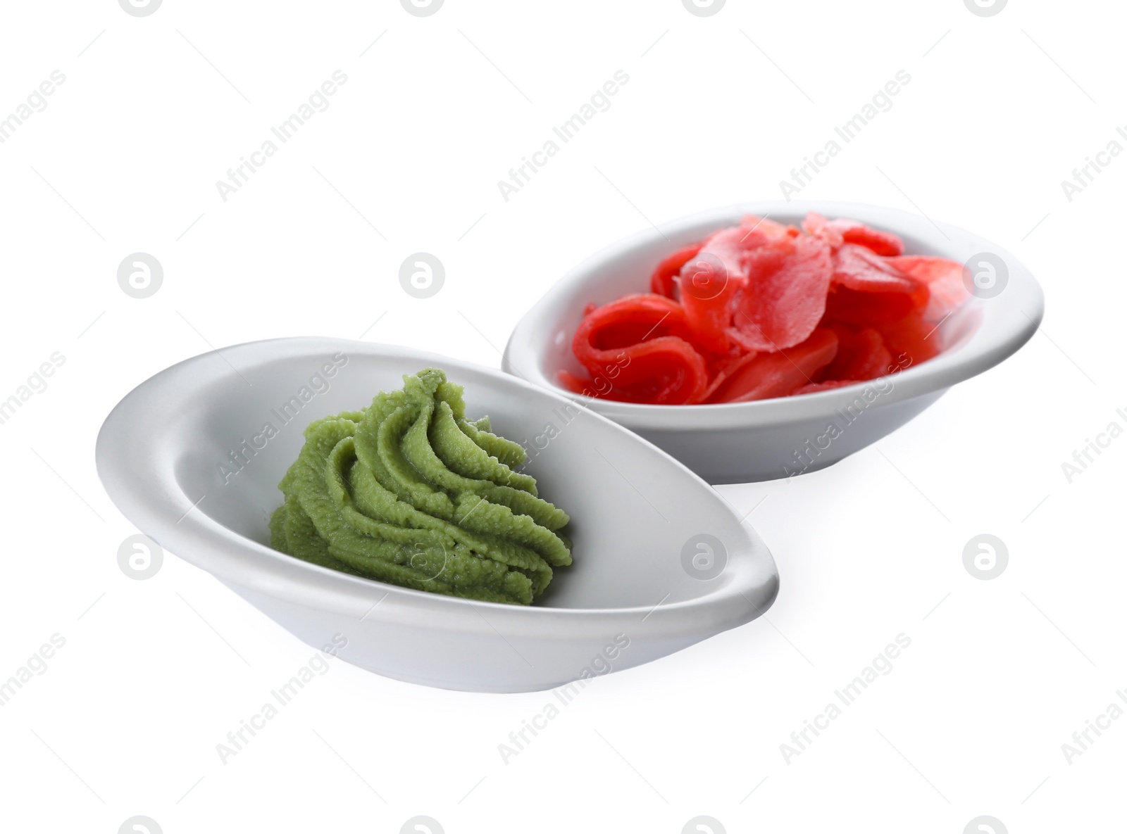 Photo of Bowls with swirl of wasabi paste and pickled ginger on white background