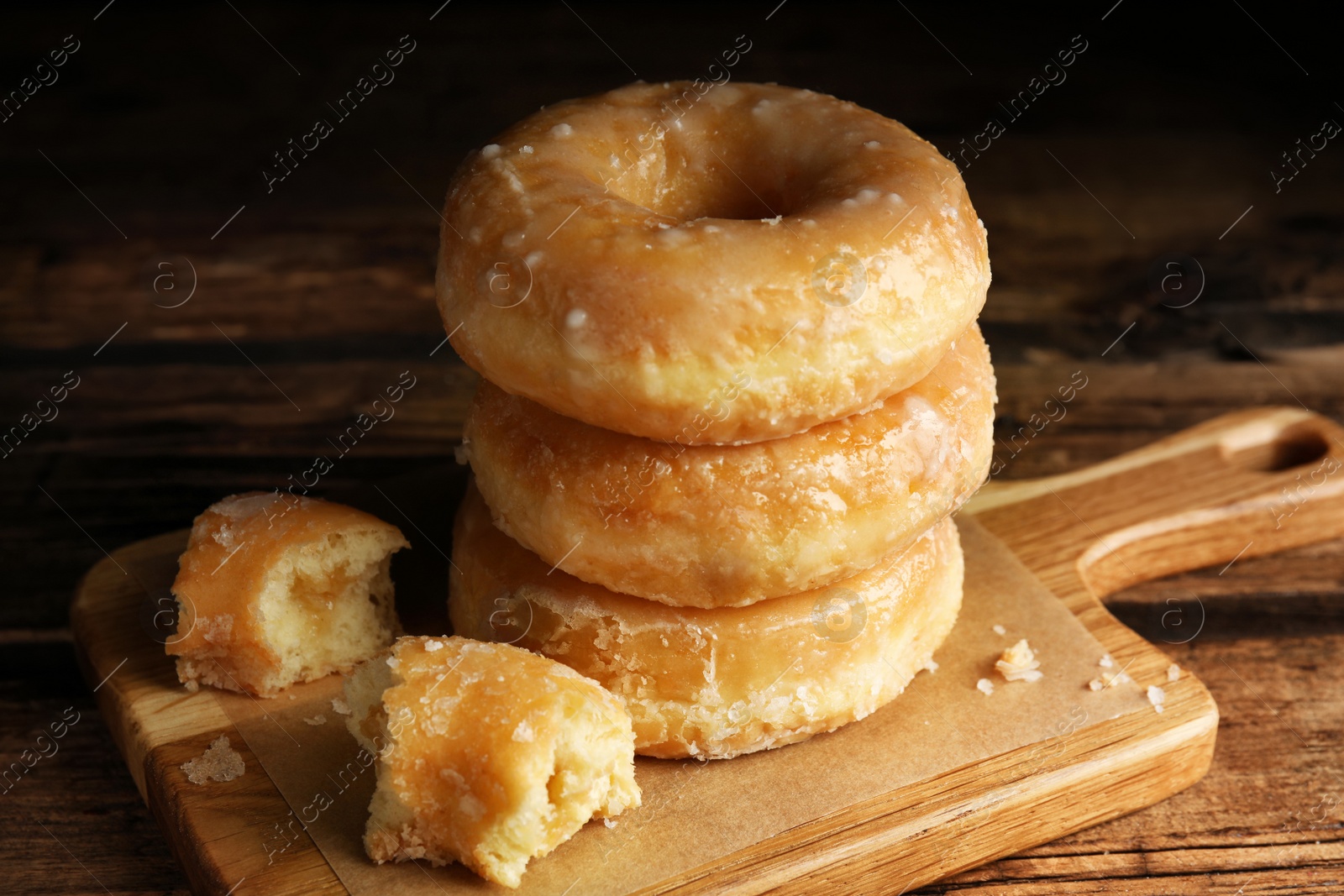 Photo of Stack of delicious donuts on wooden table