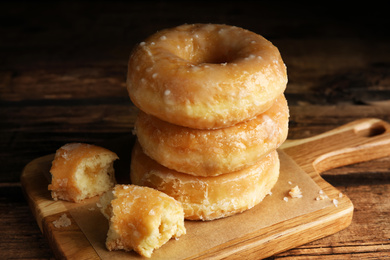Stack of delicious donuts on wooden table