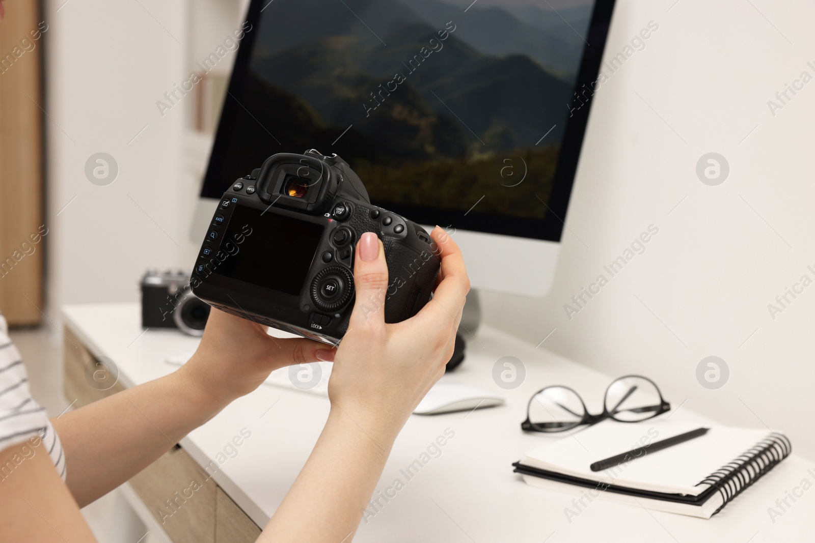 Photo of Photographer with camera at white table indoors, closeup