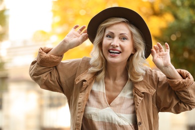 Portrait of happy mature woman with hat outdoors