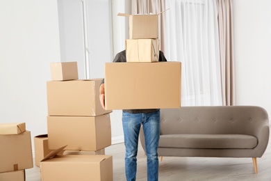 Photo of Man with moving boxes in his new house