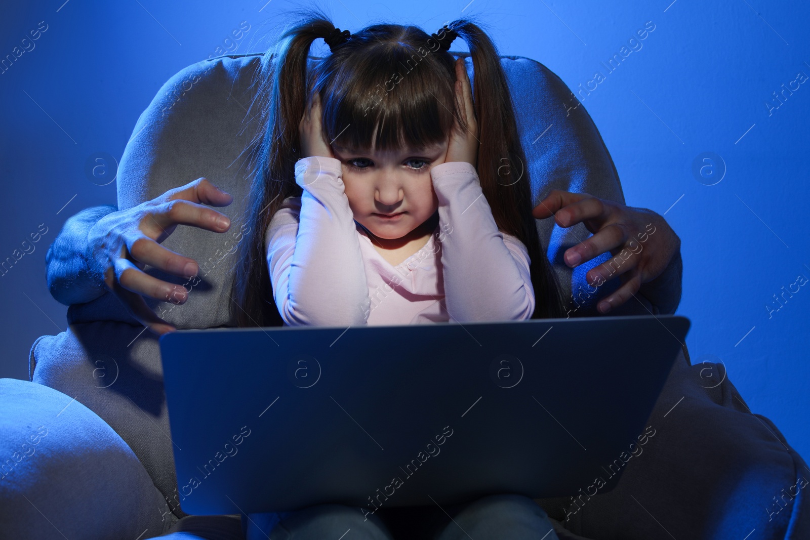 Photo of Stranger reaching frightened little child with laptop on color background. Cyber danger