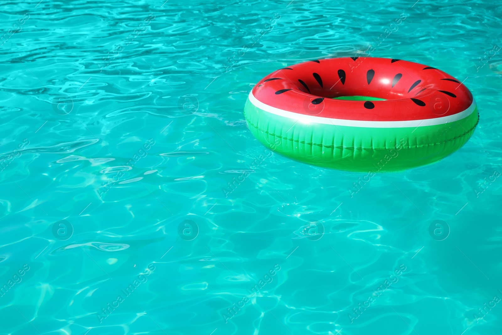 Photo of Inflatable ring floating in swimming pool on sunny day. Space for text