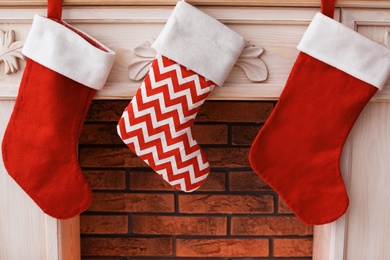 Photo of Decorative fireplace with red Christmas stockings indoors