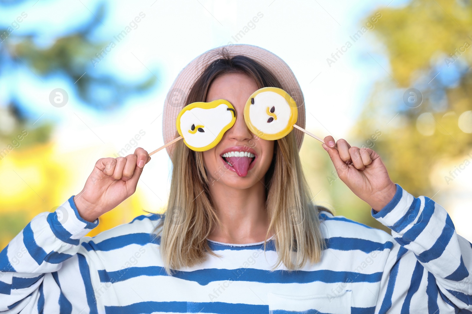 Photo of Young happy woman with sweet candies outdoors