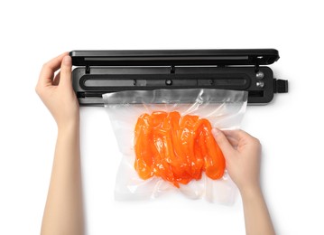 Photo of Woman using sealer for vacuum packing with plastic bag of bell pepper on white background, top view