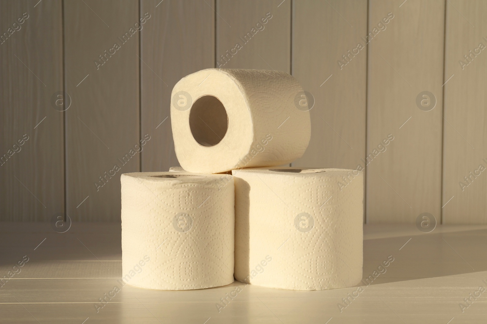 Photo of Many soft toilet paper rolls on white wooden table