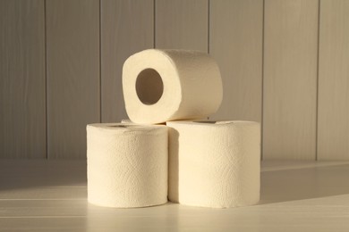 Photo of Many soft toilet paper rolls on white wooden table