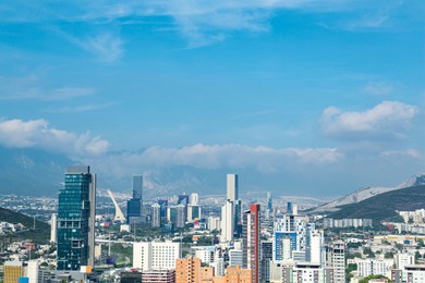 Photo of Picturesque view of cityscape with many buildings near mountain