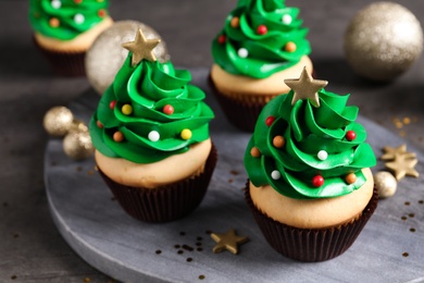 Christmas tree shaped cupcakes on grey table, closeup