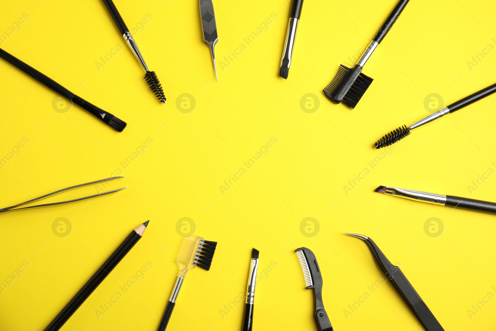 Photo of Set of professional eyebrow tools on yellow background, flat lay. Space for text