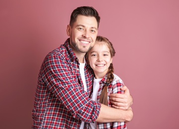 Photo of Dad and his daughter hugging on color background. Father's day celebration