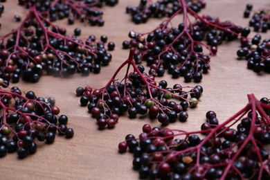 Tasty elderberries (Sambucus) on wooden table, closeup