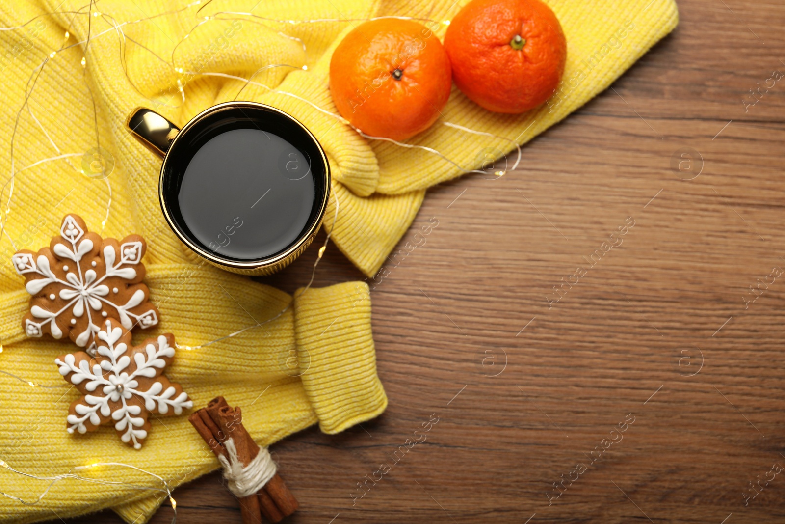 Photo of Composition with cup of hot drink and yellow sweater on wooden table, flat lay. Space for text