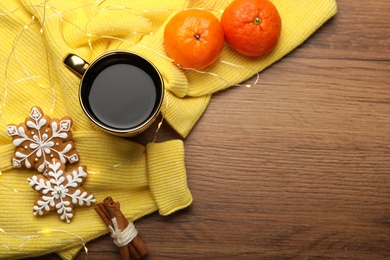 Photo of Composition with cup of hot drink and yellow sweater on wooden table, flat lay. Space for text