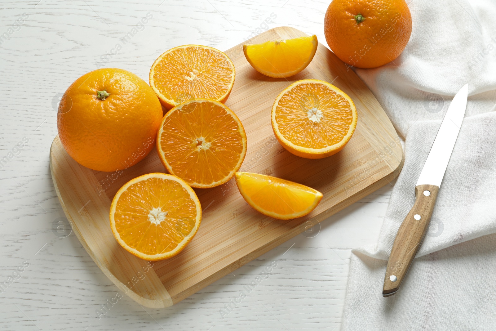 Photo of Composition with ripe oranges, cutting board and knife on table