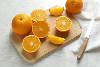 Composition with ripe oranges, cutting board and knife on table