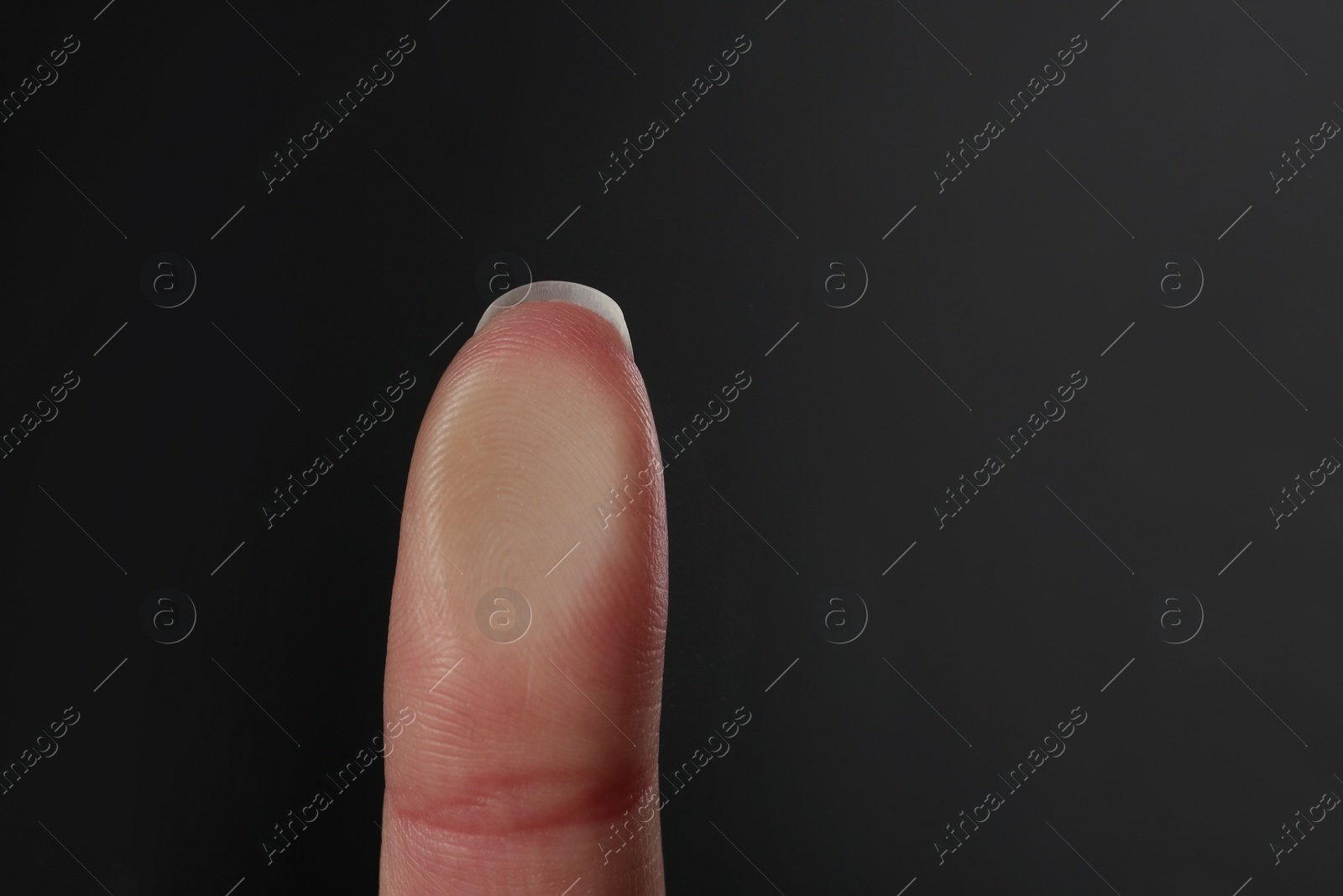 Photo of Woman pressing control glass of biometric fingerprint scanner on dark background, closeup. Space for text