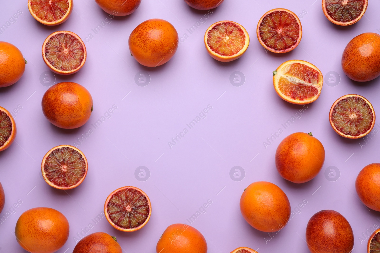 Photo of Frame of ripe sicilian oranges on violet background, flat lay. Space for text