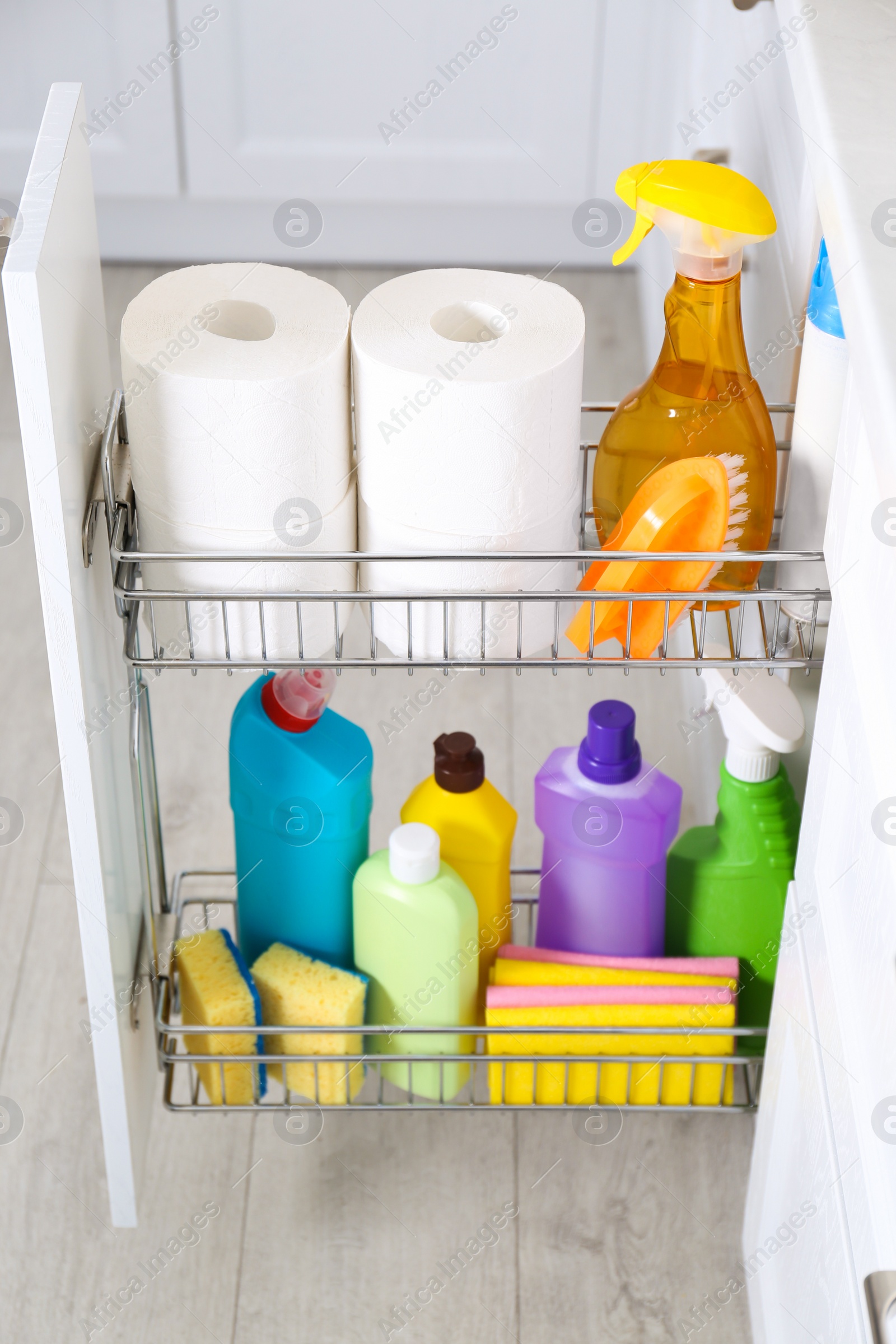 Photo of Open drawer with different cleaning supplies in kitchen