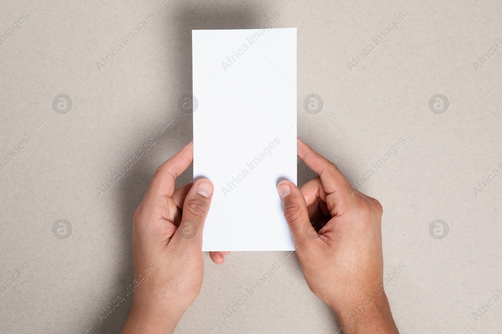 Photo of Man holding flyer on grey background, closeup. Mockup for design