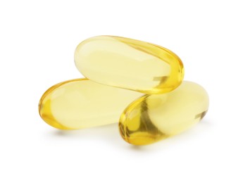 Photo of Many yellow vitamin capsules isolated on white