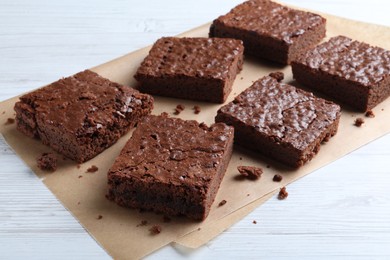 Photo of Delicious chocolate brownies on white wooden table
