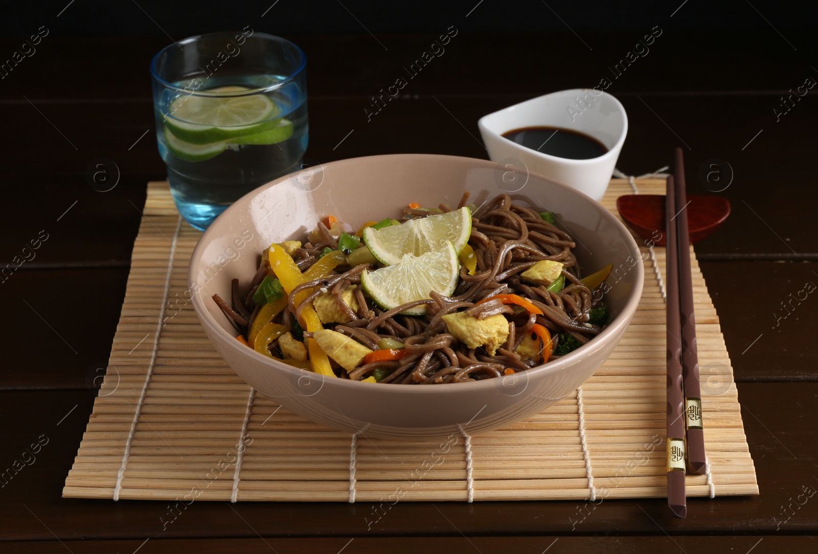 Photo of Stir-fry. Delicious cooked noodles with chicken and vegetables in bowl served on wooden table