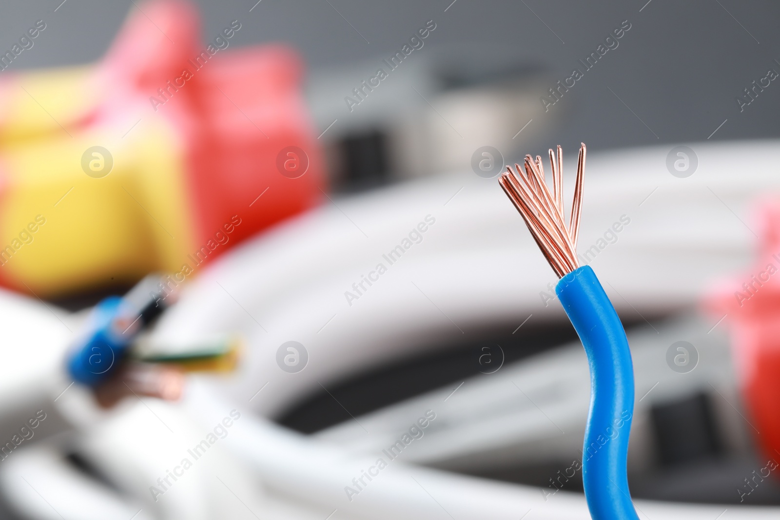 Photo of New colorful electrical wire on blurred background, closeup. Space for text