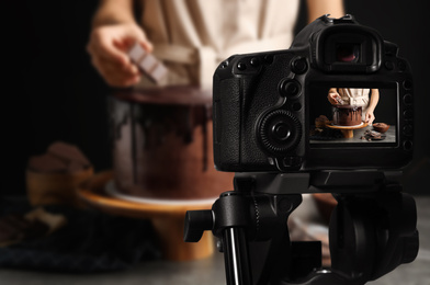 Food photography. Shooting of chef decorating chocolate cake, focus on camera