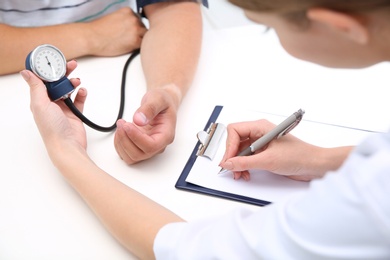 Doctor checking young man's pulse in hospital