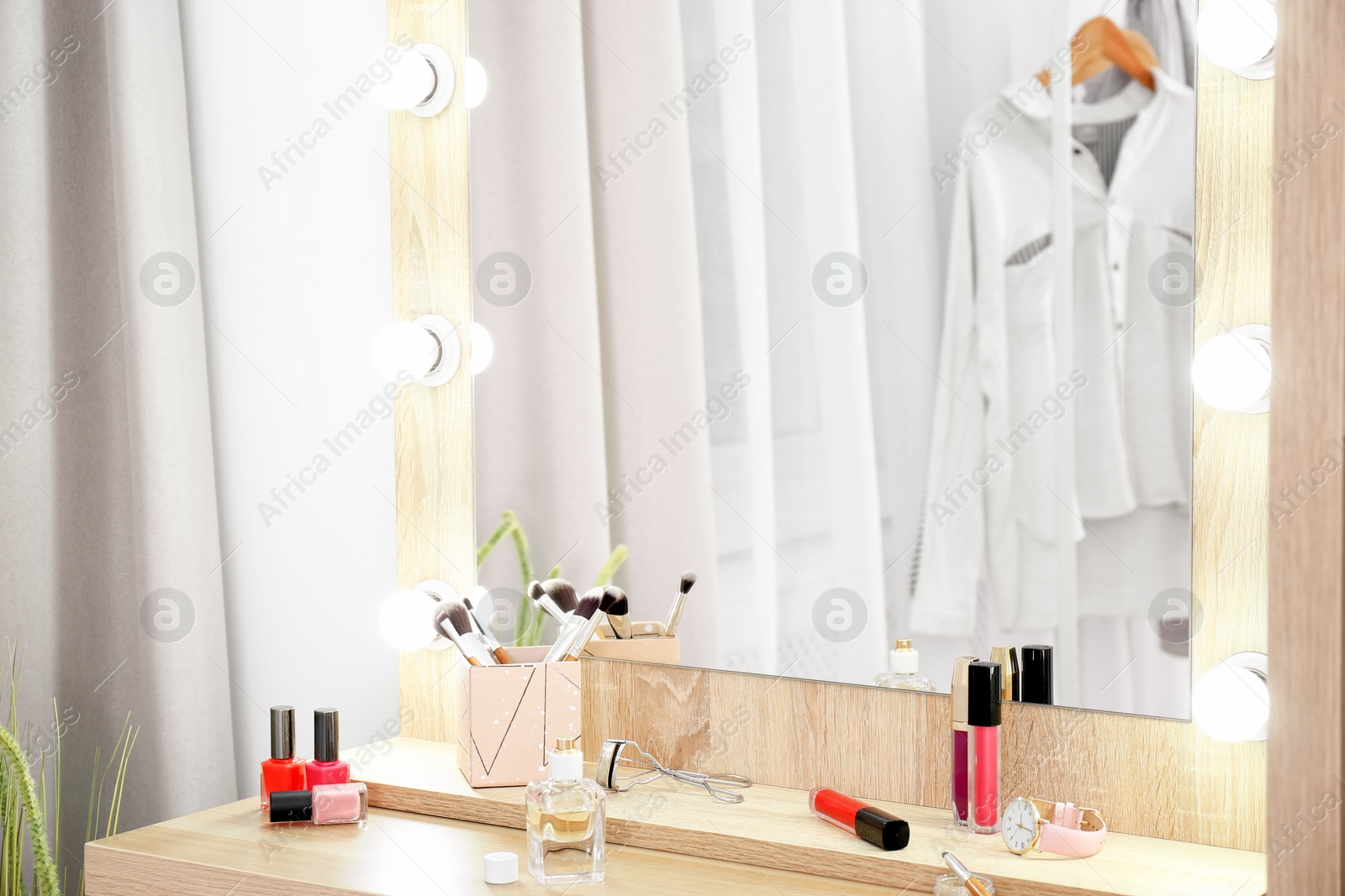 Photo of Makeup mirror on table near white wall in dressing room