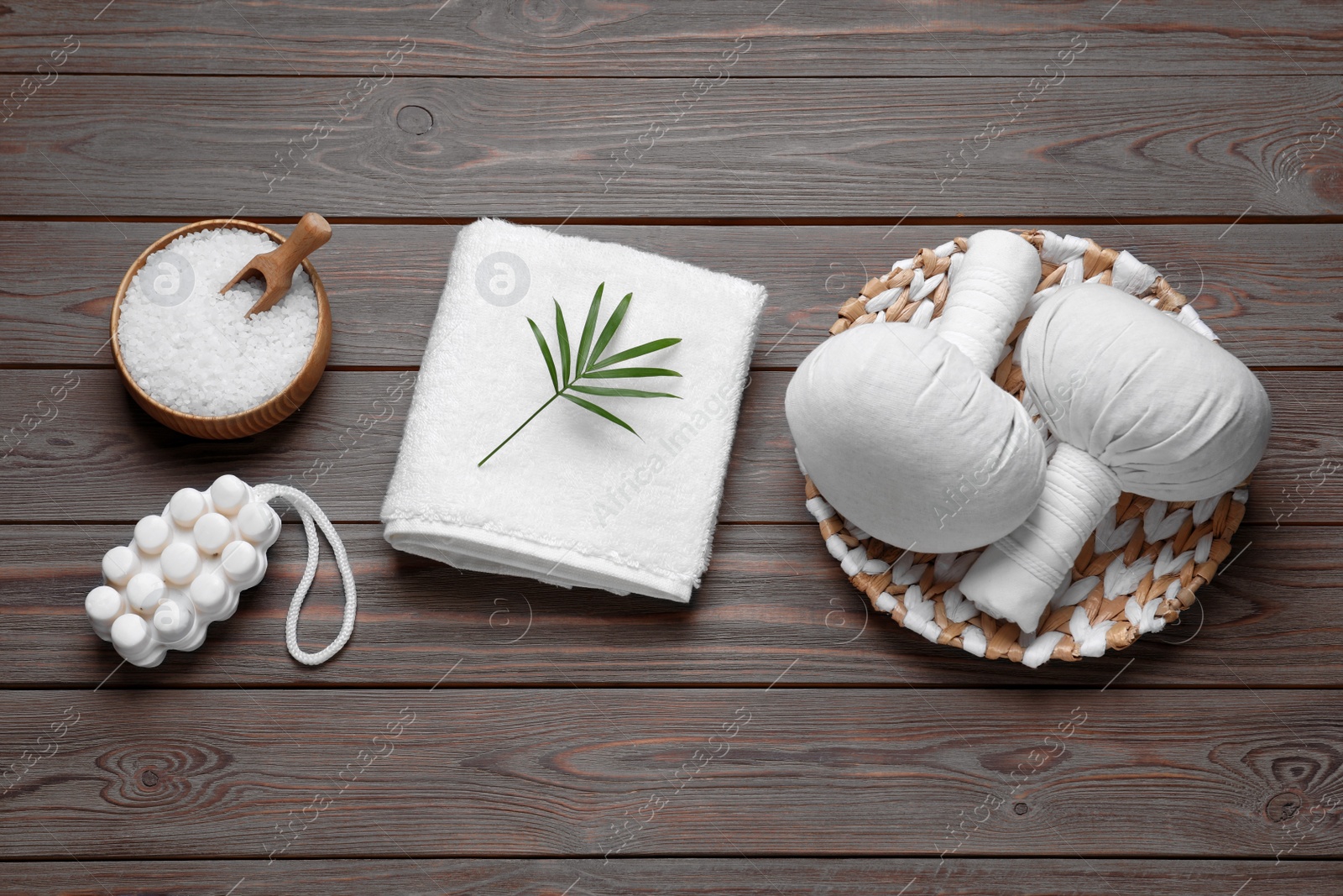Photo of Flat lay composition of herbal bags and spa products on wooden table