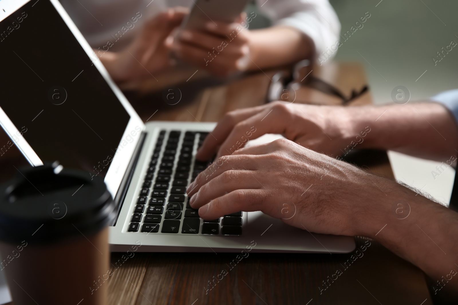 Photo of Businessman working on laptop in office, closeup. Professional communication