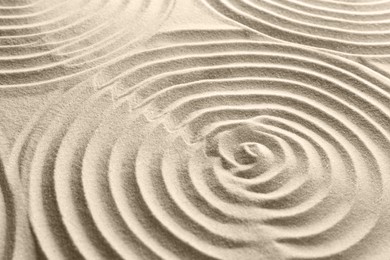 Photo of Beautiful patterns on sand, closeup. Zen garden