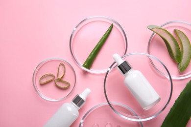 Photo of Flat lay composition with aloe vera leaves and cosmetic products on pink background. Space for text