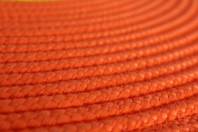 Photo of Texture of orange wicker mat as background, closeup view