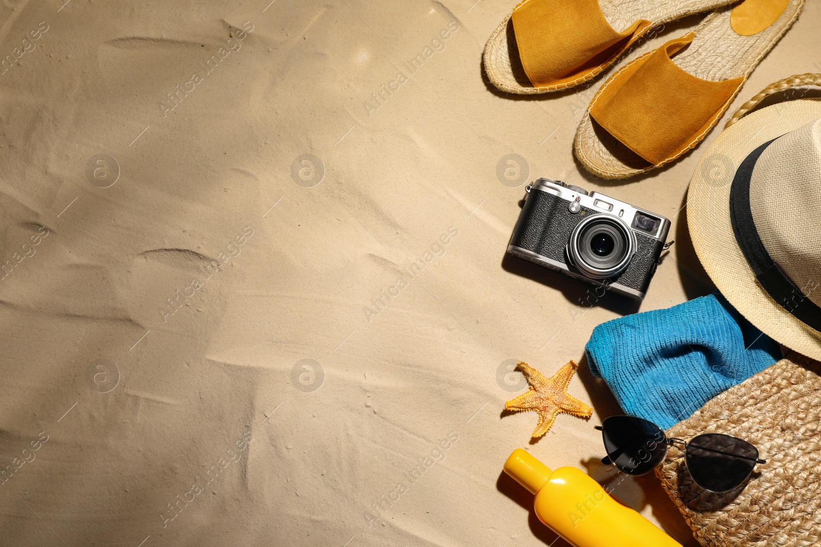Photo of Beach accessories on sand, flat lay. Space for text