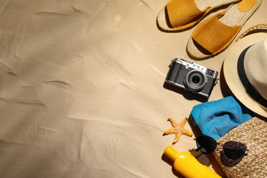 Photo of Beach accessories on sand, flat lay. Space for text