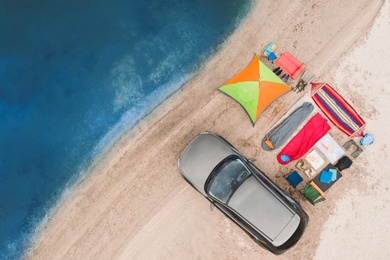 Image of Car and camping equipment on sandy beach, aerial view. Summer trip